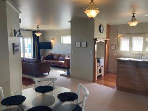 a living room with a table and chairs at Beachfront Villa in Napier