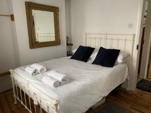 a bedroom with a white bed with towels on it at The Pepper Pot in Lympstone