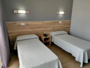 ein Zimmer mit zwei Betten und zwei Lampen an der Wand in der Unterkunft Hotel Reymar in Malgrat de Mar