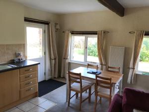 a kitchen and dining room with a table and chairs at Locka Old Hall Cottage in Arkholme