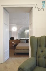 een slaapkamer met een bed, een bank en een stoel bij Le Camere dell’Emiro in Castronuovo di Sicilia