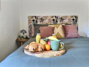 a tray of fruit and bread on a bed at LE LIMOUCHE Proche Centre Parking Gratuit in Chabeuil