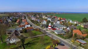 una vista aérea de una pequeña ciudad con un faro en Leuchtfeuer Fewo "Andersen", en Börgerende-Rethwisch