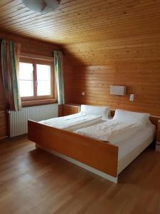 1 dormitorio con 2 camas en una habitación de madera en Ferienwohnung Helma, en Blons