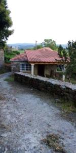 une maison en pierre avec un toit rouge dans l'établissement 4 bedrooms house with garden and wifi at Lugo Galicia, à Argozón