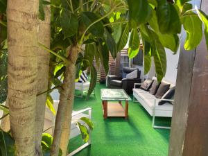 uma sala de estar com pisos verdes e uma árvore em LOFT FAMILIAR EN LA PLAYA em Marbella