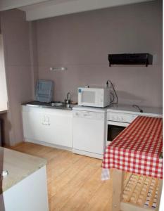 une cuisine avec un évier et un micro-ondes sur un comptoir dans l'établissement Maison charmante à Jugon-les-Lacs avec jardin, à Jugon Les Lacs