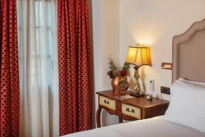 a bedroom with a bed and a table with a lamp at ARCHONTARIKI Historic Boutique Hotel in Ioannina