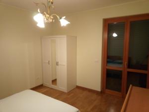 Schlafzimmer mit einem Bett, einem Fenster und einem Kronleuchter in der Unterkunft A CASA DI LUCA E GLORIA 2 in Giulianova