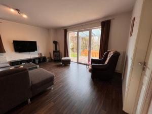 a living room with a couch and a tv at Leuchtfeuer Fewo "Chris" in Börgerende-Rethwisch