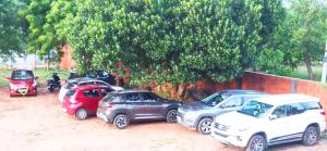 a row of parked cars parked next to a tree at Wow Farm House in Auroville +53 photos