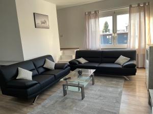 un soggiorno con divano nero e tavolo di E&B Apartments Korb a Korb