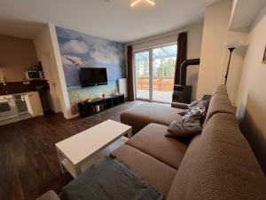 ein Wohnzimmer mit einem Sofa und einem TV in der Unterkunft Leuchtfeuer Fewo "Kimberly" in Börgerende-Rethwisch