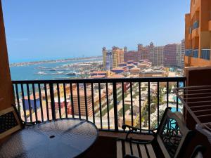 uma varanda com uma mesa e cadeiras e o oceano em sea view apartment in Porto Marina em El Alamein