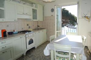 a kitchen with white cabinets and a table and a window at Appartamento giumin in Corniglia