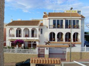 een wit huis met een hek ervoor bij 2 bedrooms apartement at Mazarron 400 m away from the beach with sea view shared pool and jacuzzi in Mazarrón