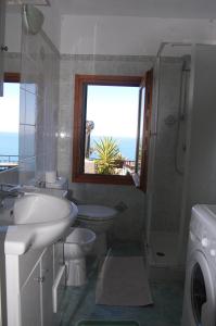bagno con lavandino, servizi igienici e finestra di Appartamento giumin a Corniglia