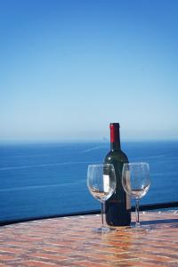 a bottle of wine and two wine glasses on a table at Appartamento giumin in Corniglia