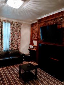Una sala de estar con un sofá y un televisor de pantalla plana. en Hotel Edward Paddington, en Londres