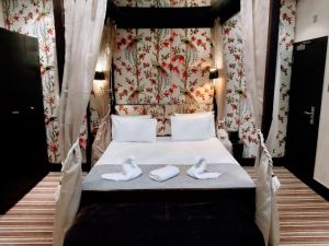 a bedroom with a bed with two swans on it at Hotel Edward Paddington in London
