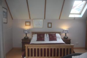 a bedroom with a bed with two lamps on tables at The Garden Room at Dartmouth in Dartmouth