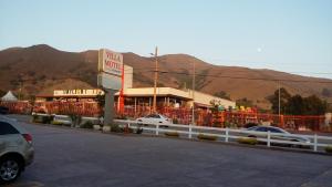 un motel con montagne sullo sfondo di un parcheggio di Villa Motel a San Luis Obispo