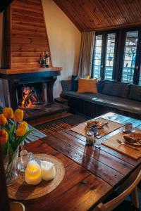 un soggiorno con tavolo e camino di The Happy Cottage a Ioannina
