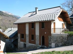 una casa con un techo de estaño encima en Gîte d'étape La Pierre en Saint-Colomban-des-Villards