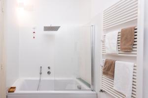 een witte badkamer met een douche en een bad bij B&B Angioy 18 in Cagliari