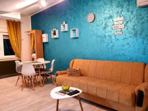 sala de estar con sofá y pared azul en Apartman Azra, en Kikinda