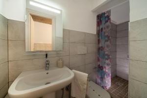 Un baño con lavabo, inodoro y espejo. en appartamento Porta Pia, en Roma 31 fotos más