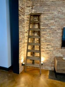 een houten ladder die tegen een stenen muur leunt bij The Loft, by So & Dam’s in Thonon-les-Bains