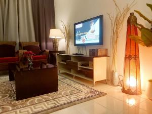 uma sala de estar com televisão numa mesa em Islamic Homestay Apartment Kundang, Rawang em Rawang