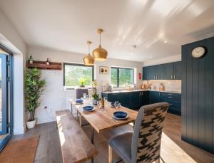 uma cozinha e sala de jantar com uma mesa de madeira e cadeiras em Luxury Detached House on Redwalls, Dartmouth em Dartmouth