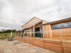 a house with a wooden exterior with a patio at Stables Lodge in Chesterfield