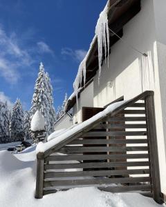 un edificio cubierto de nieve con carámbanos colgando de él en Apartma Idila, en Zreče