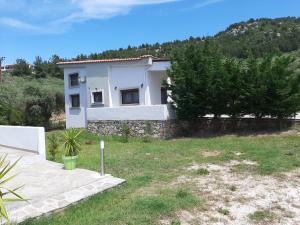 帕奇斯Olia Garden的一座小白色房子,后面有一座小山