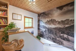 ein Zimmer mit einem Wandbild von Bergen in der Unterkunft Oberglarzhof App Zirbel in Villnöß