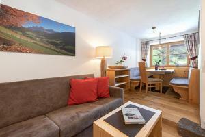 un soggiorno con un divano e un tavolo di Oberglarzhof App Zirbel a Villnoss