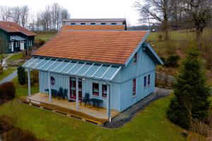 uma vista superior de uma casa azul com um deque em Ferienhaus Nr 15C, Feriendorf Hagbügerl, Bayr Wald em Waldmünchen