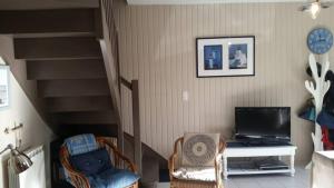 een woonkamer met 2 stoelen en een trap bij La Petite Maison de Kergroix // Mer et Maisons in Carnac