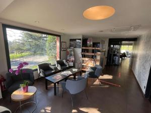 a living room with couches and chairs and a large window at Kyriad Lyon Sud Sainte Foy in Sainte-Foy-lès-Lyon