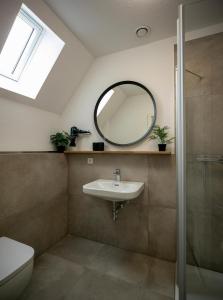 uma casa de banho com um lavatório e um espelho em Plauderei Café und Hotel em Bad Zwischenahn