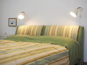 Una cama con una manta verde y amarilla. en Villa Bismarckshöhe Wohnung Gertrud, en Ahlbeck