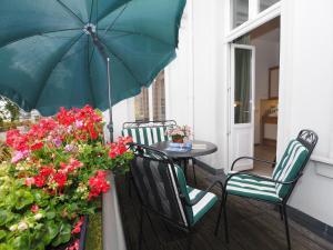 un patio con mesa, sillas y sombrilla en Villa Bismarckshöhe Wohnung Gertrud, en Ahlbeck