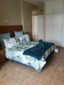 a bedroom with a bed with a blue comforter at 106 Umdloti Resort in Umdloti +7 photos