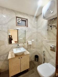 a bathroom with a white toilet and a sink at Hotel Tripple Tree - Karol Bagh in New Delhi