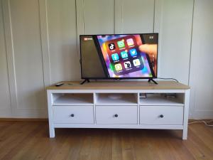 a flat screen tv sitting on a white dresser at Apartment Meinradsberg mit Balkon in Einsiedeln