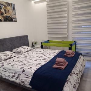 a bedroom with a bed with towels on it at Chill Out Apartment in Novi Sad