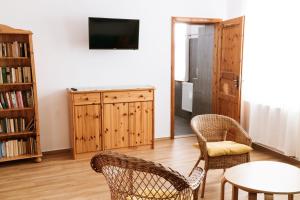 a living room with two chairs and a table and a tv at Ferienwohnung an der Berliner Seenkette in Schwerin